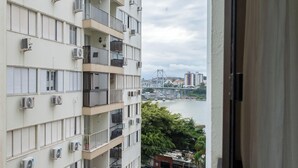 A multi-story building with balconies, air conditioning units, and a view of a bridge and river. - Apt 3 Bedrooms in Floripa Downtown Idr0801 (Florianópolis)
