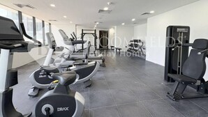 Ein modernes Fitnessstudio mit Laufbändern, Crosstrainern und Gewichten.