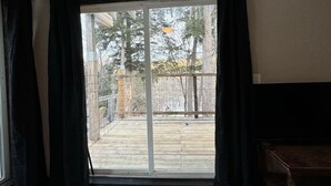 A room with a large sliding glass door leading to an outdoor deck.