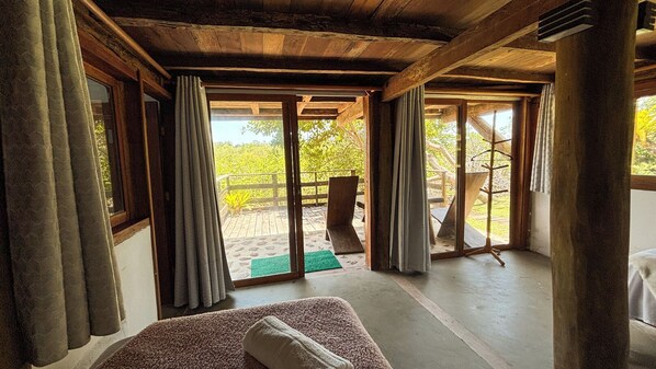 A room with a large sliding glass door leading to an outdoor patio area. - Bangal Beira da Lagoa com Acesso Direto Praia (Prado)
