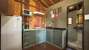 A compact kitchen with a refrigerator, microwave, and coffee maker. - Bangal Beira da Lagoa com Acesso Direto Praia (Prado)