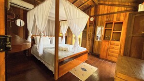 A four-poster canopy bed in a wooden room with a wooden cabinet and a small table. - Bangal Beira da Lagoa com Acesso Direto Praia (Prado)