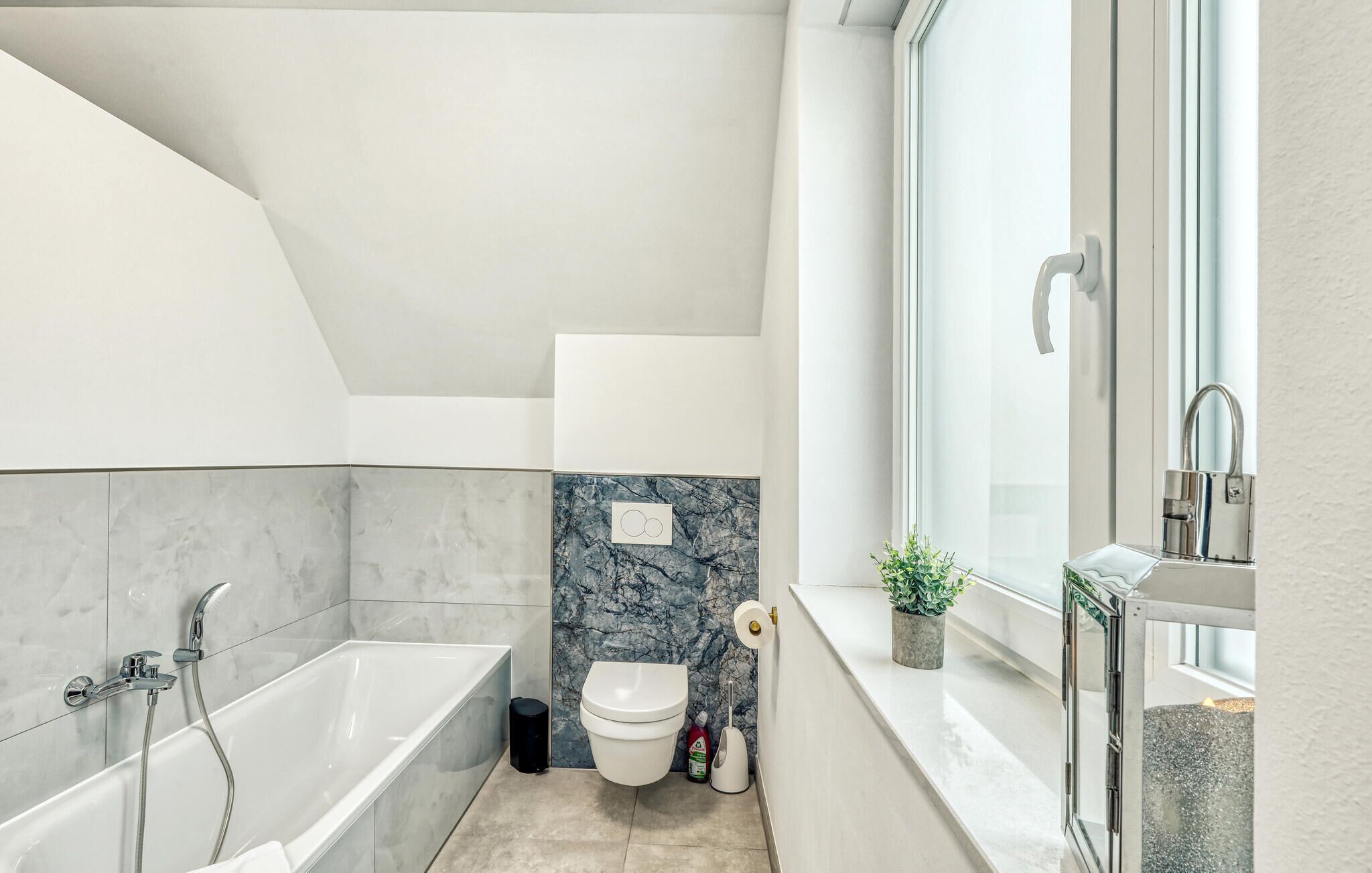 Une salle de bain moderne équipée d’une baignoire, de toilettes et d’une douche.