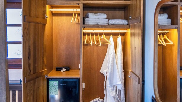 Een houten badkamer met een ingebouwd wastafel, handdoekhouder en spiegel.