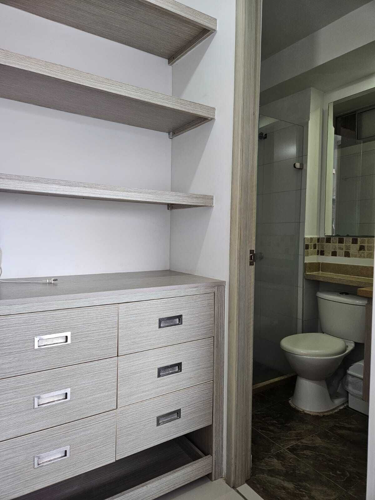 Un bagno con il water, uno specchio e un pavimento piastrellato.