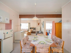 A compact living space with a dining area, kitchenette, and a living room. - Hosts on the Coast Cosy on Cooks (Cooks Beach)