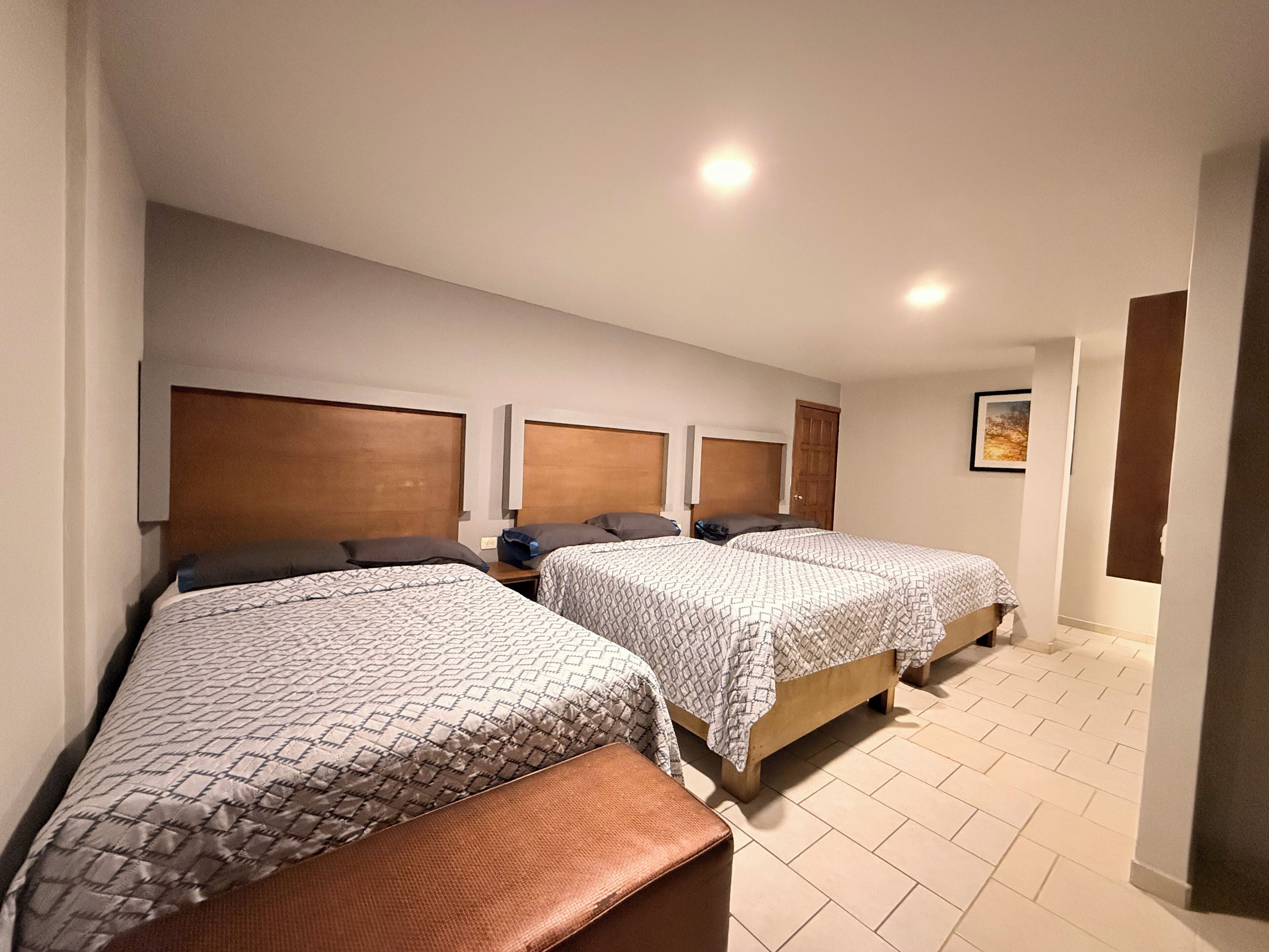 Een hotelkamer met twee bedden, een bank en een deur.