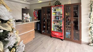 A hotel lobby with a Christmas tree, a Coca-Cola refrigerator, and a wooden cabinet with glass doors. - Hotel Mirage Diagonal (Matamoros)