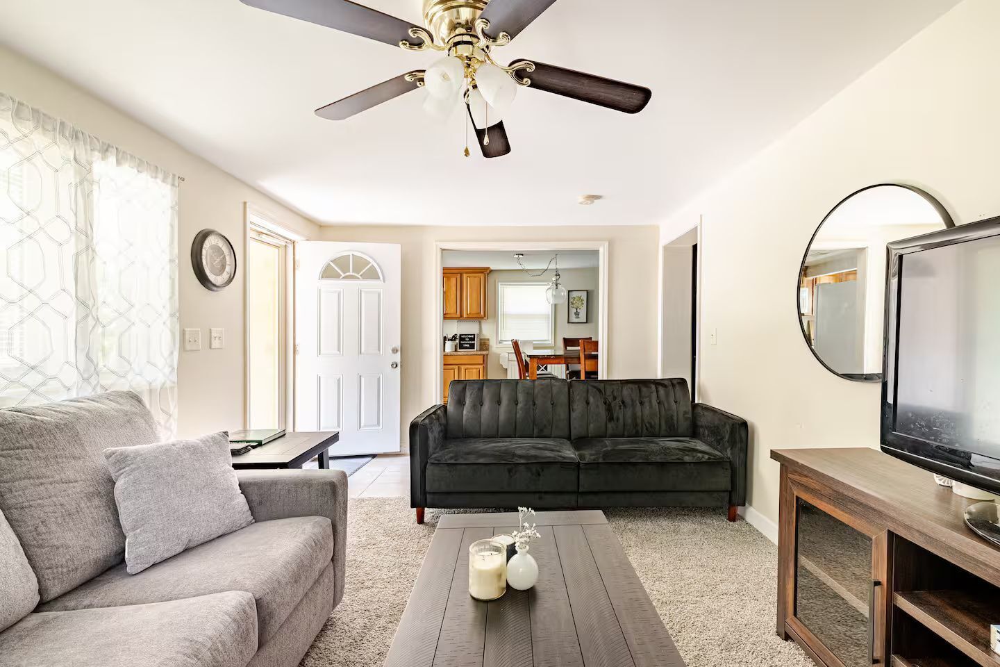 Living room featuring upholstered seating, a coffee table, and a view into the kitchen.