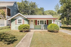 Front exterior view of the single-story green home, porch, and walkway. - Nashville Getaway with Workspace & Pets (Nashville)