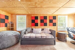 A wood-paneled lounge space featuring a daybed, beanbag, and acoustic wall panels. - Nashville Getaway with Workspace & Pets (Nashville)