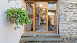 A stone building entrance with a wooden door, a hanging plant, and a sign reading 'ROYAL OAK BARN'. - Royal Oak Barn - Cartmel, Sleeps 8! (NEW) (Cartmel)