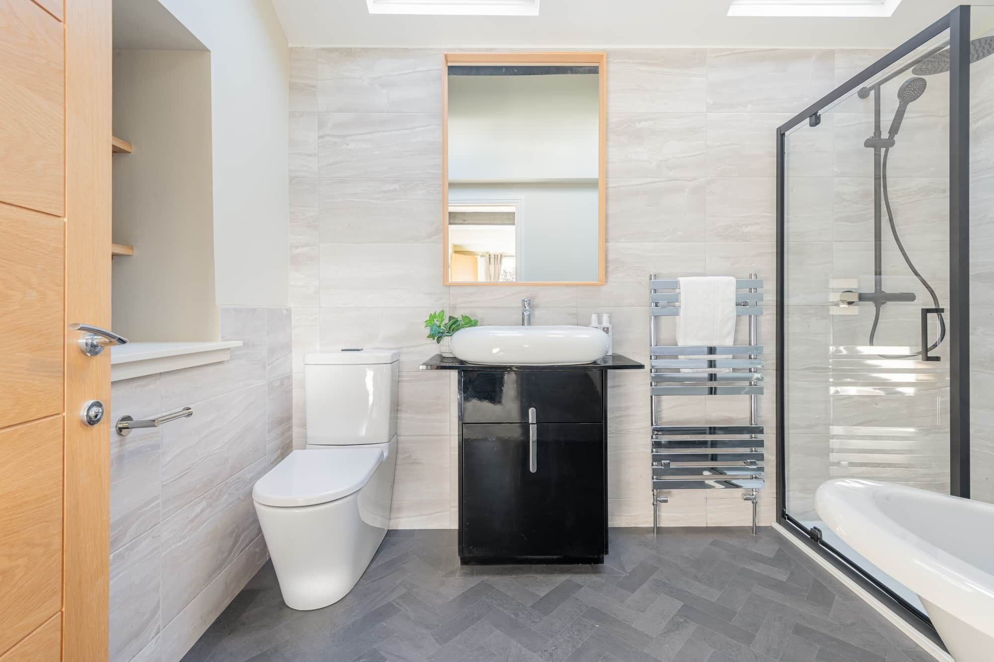 A modern bathroom with a toilet, sink, and shower.