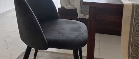 Ein modernes Hotelzimmer mit großem Fenster, einem wandmontierten Flachbildfernseher, einem Holztisch und einem bequemen Sessel.