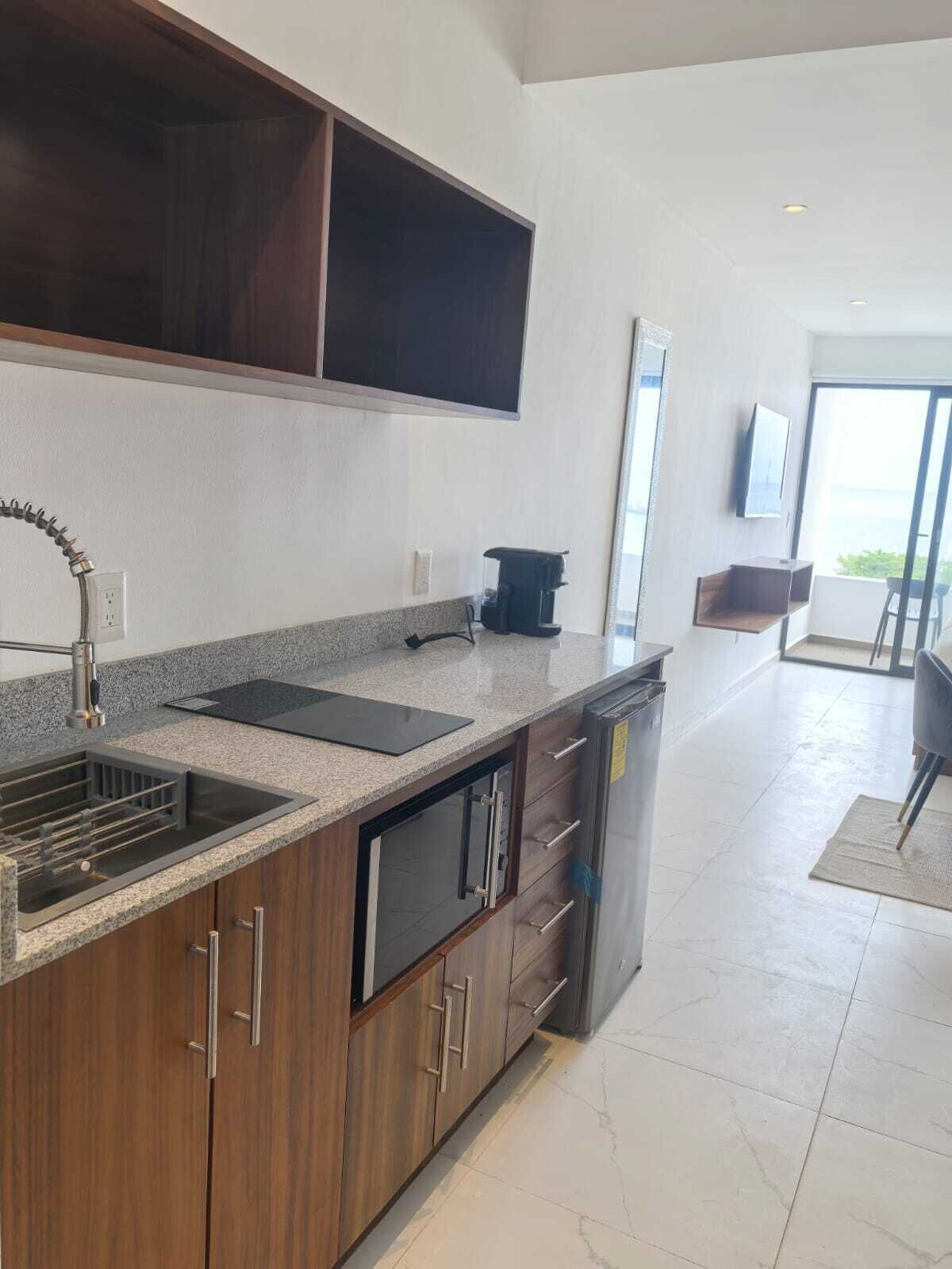 Una cocina moderna con encimera de granito, electrodomésticos de acero inoxidable y armarios de madera.
