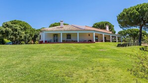 A single-story house with a tiled roof, a covered porch, and a grassy lawn. - 188 - Quinta da Sobreda (Benavente)