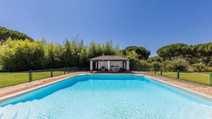 A rectangular swimming pool with a covered pavilion in the center, surrounded by a fence and trees. - 188 - Quinta da Sobreda (Benavente)