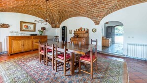 A dining area with a brick ceiling, wooden furniture, and a patterned rug. - 188 - Quinta da Sobreda (Benavente)