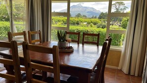 Una mesa de comedor con sillas de madera, una planta en maceta y un letrero de bienvenida.