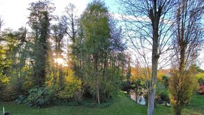 A garden with a bench, trees, and a small pond. - Bubble house, Jacuzzi, Au Calme Absolu (Lindry)