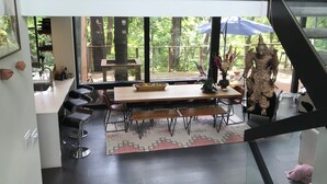Un espace repas moderne avec une table en bois, des chaises et une statue décorative.