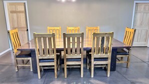 A dining table with six wooden chairs, a chandelier, and two wooden doors. - Family Retreat with pool table and double bunks. (Bethany)