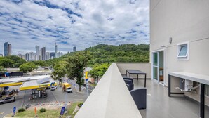 A view of a cityscape with a gas station and a building with a balcony. - Your Complete Stay Just Minutes From the sea in BC Stls (Balneário Camboriú)