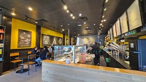 Un café avec un comptoir, un espace pour s’asseoir et des panneaux affichant le menu.