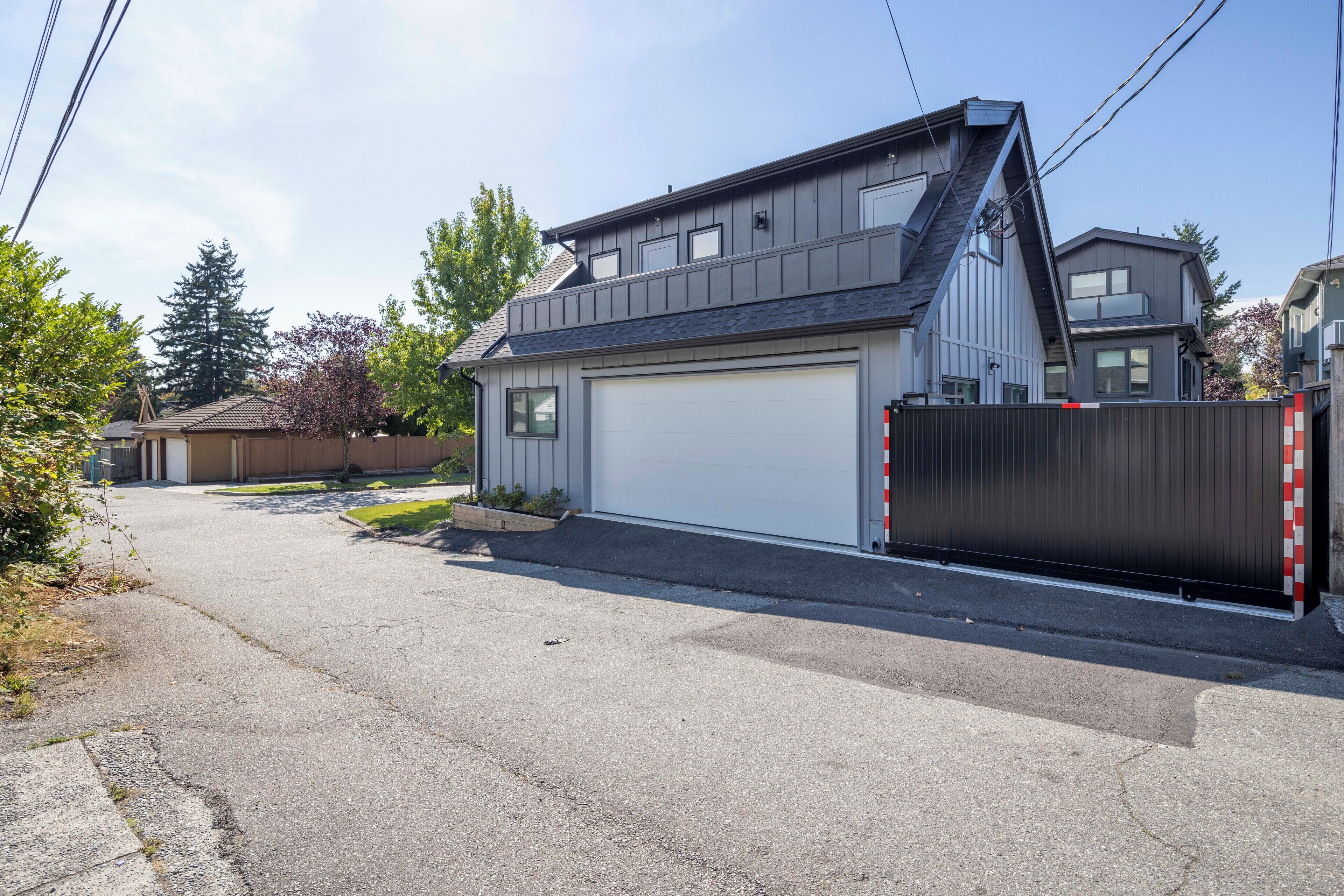 A residential house with a garage, a driveway, and a gated entrance.