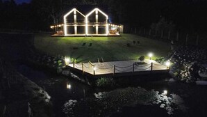 A house with a glass facade and a deck extending over a body of water. - Cozy home in Sianowo with house sea view (Sianowo)