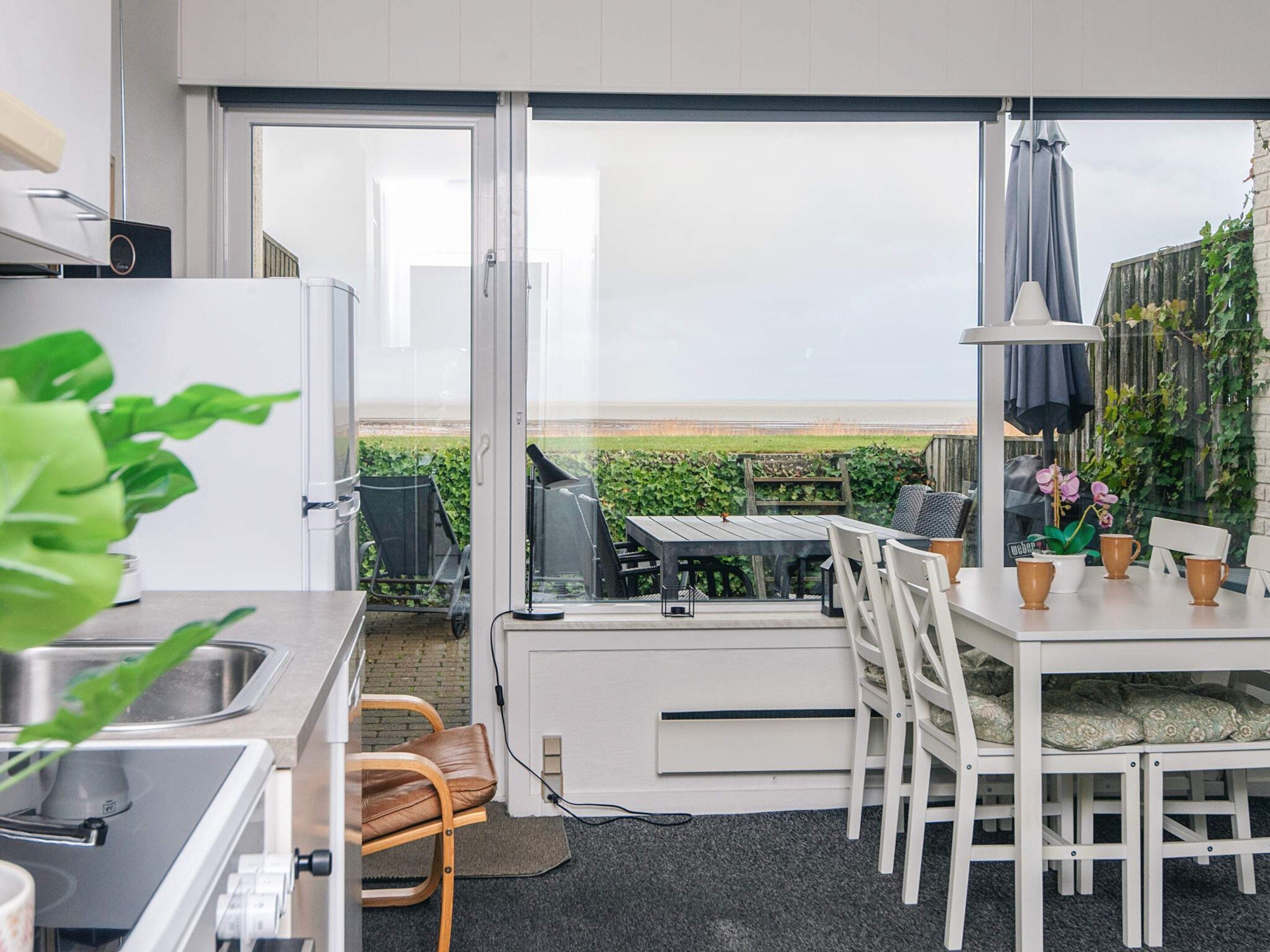 A modern kitchen with a view to a garden and outdoor seating area.