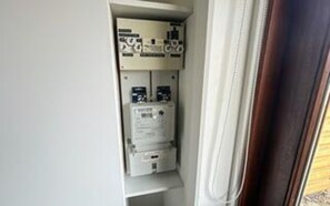 A utility panel with electrical components and a window with curtains. - 4 Person Holiday Home in Romo (Rømø)