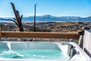 A hot tub with a view of mountains and a forested landscape. - Sunset View A Frame: Privacy, Hot Tub, Pet Friendly, Mid-Mod Vibes (Jefferson)