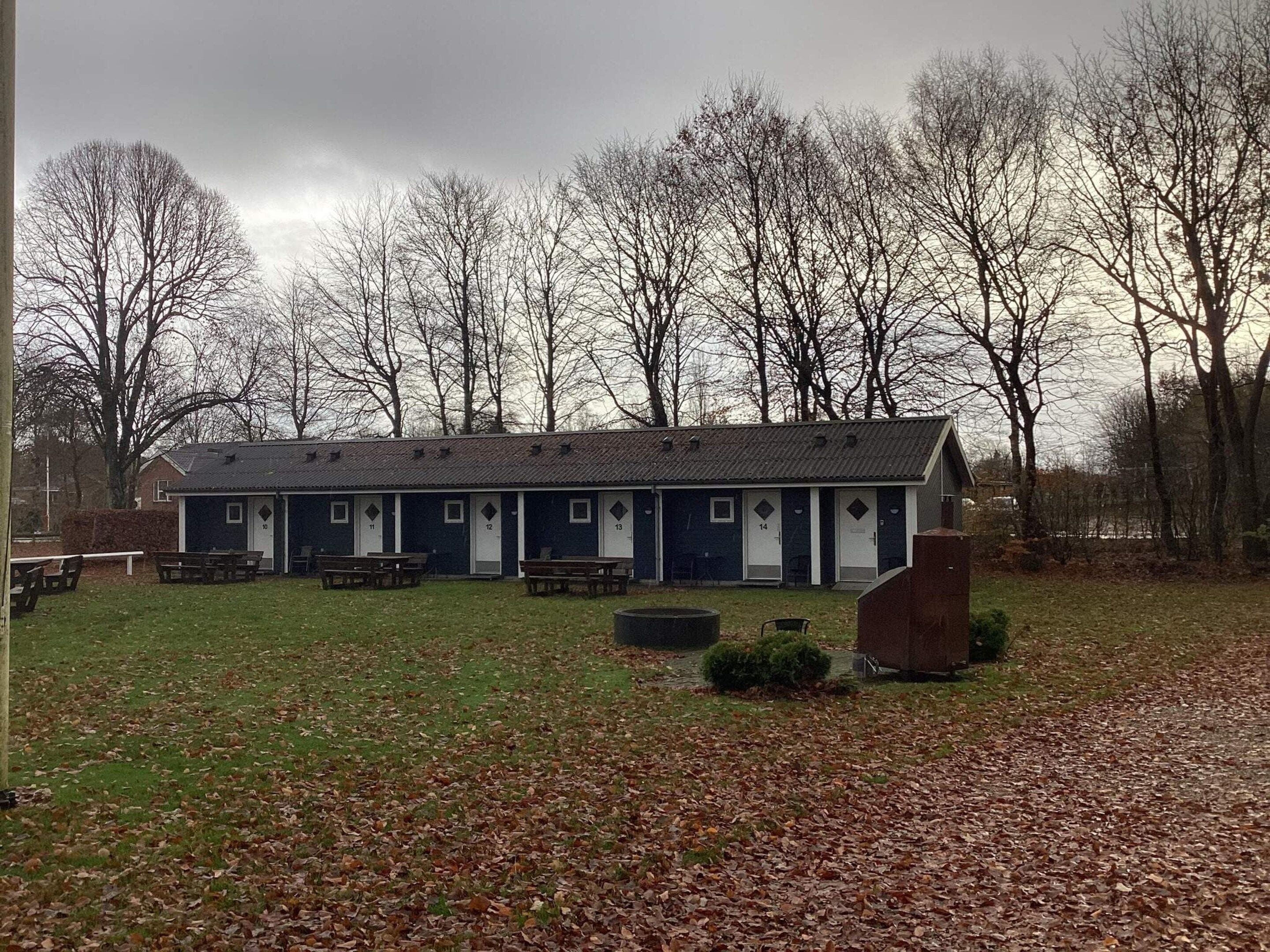 A row of numbered rooms with a covered outdoor area in front.