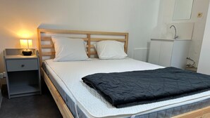 A single bed with a wooden frame, a bedside table with a lamp, and a small cabinet. - Holiday Home in Ruisseau de Vaux (Villers-le-Bouillet)
