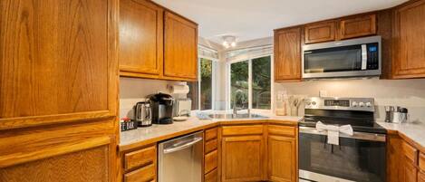 A kitchen with wooden cabinets, stainless steel appliances, and a built-in microwave.