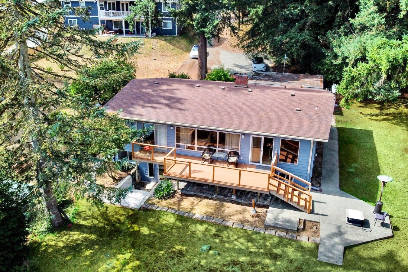 A two-story house with a deck, a covered porch, and a small front yard.