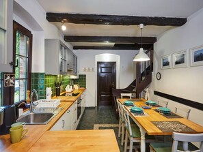 A kitchen with wooden countertops, a sink, and a dining area with a table and chairs. - Large Holiday Home, Summer Pool, Sauna, Whirlpool (Choczewo)