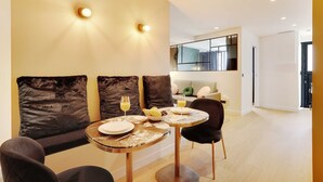 A dining area with a table set for two, two glasses of orange juice, and a bowl of fruit. - Serene Apartment for 6p Near the Marais (Paris)