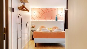 A bedroom with a bed, bedside table, and a wall-mounted light fixture. - Serene Apartment for 6p Near the Marais (Paris)