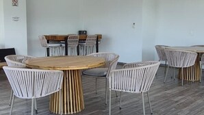 A spacious room with a large wooden table surrounded by white chairs, a clock on the wall, and an air conditioning unit. - Relax, Unwind and Experience Vallarta (Puerto Vallarta)