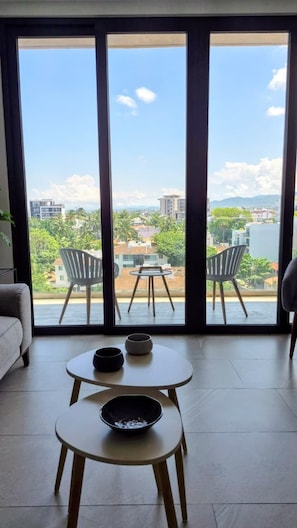 A room with a large sliding glass door leading to a balcony with two chairs and a table. - Relax, Unwind and Experience Vallarta (Puerto Vallarta)