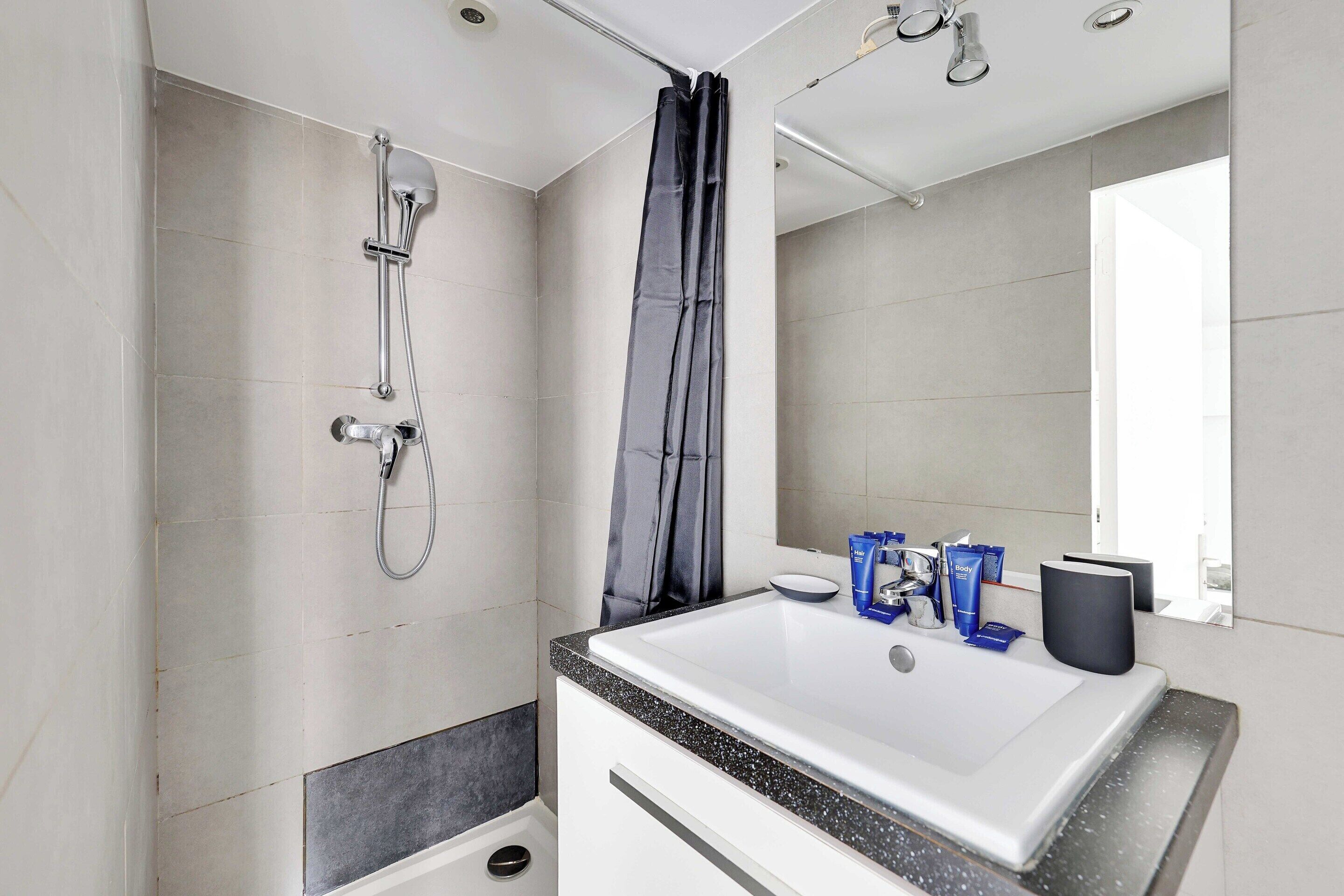 Appartement | Badkamer | Een haardroger, handdoeken, shampoo