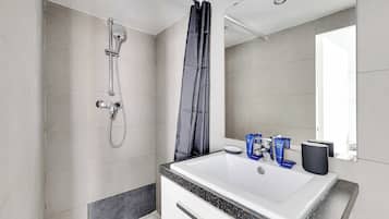 Appartement | Badkamer | Een haardroger, handdoeken, shampoo