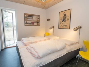A hotel room with two beds, a large window, a framed picture, and a yellow chair. - 5 Star Holiday Home in Vestervig (Vestervig)
