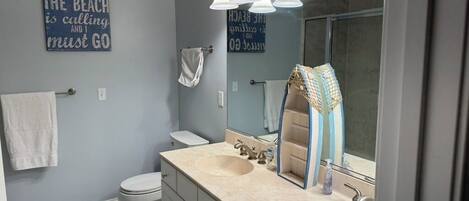 A bathroom with two sinks, a toilet, a towel rack, and a mirror.