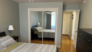 A bedroom with a bed, a nightstand, a dresser, and a mirror. - Cute 1-bedroom condo in Denver's Cap Hill neighborhood (Denver)