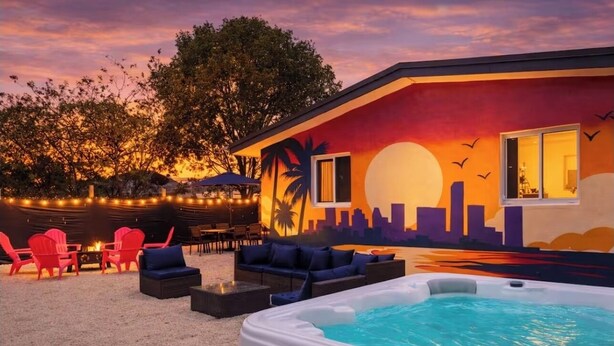 Un hôtel doté d’une piscine sur le toit, d’un espace extérieur aménagé et d’une fresque représentant un coucher de soleil.