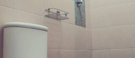Un baño con inodoro, toallero y ducha.