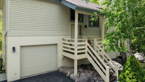 Ein zweistöckiges Haus mit überdachter Veranda und Garage.